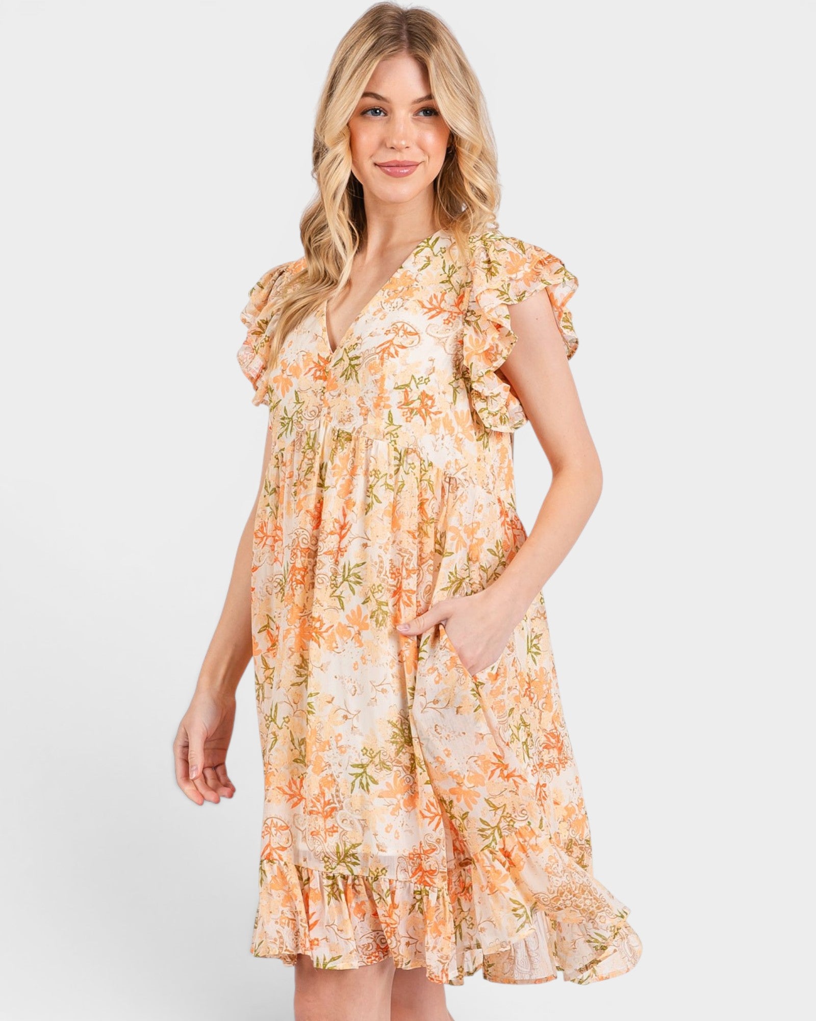 Woman wearing a floral dress with ruffled sleeves on a white background