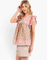 A woman modeling a short-sleeve floral top with ruffled sleeves and beige shorts against a plain white studio background.