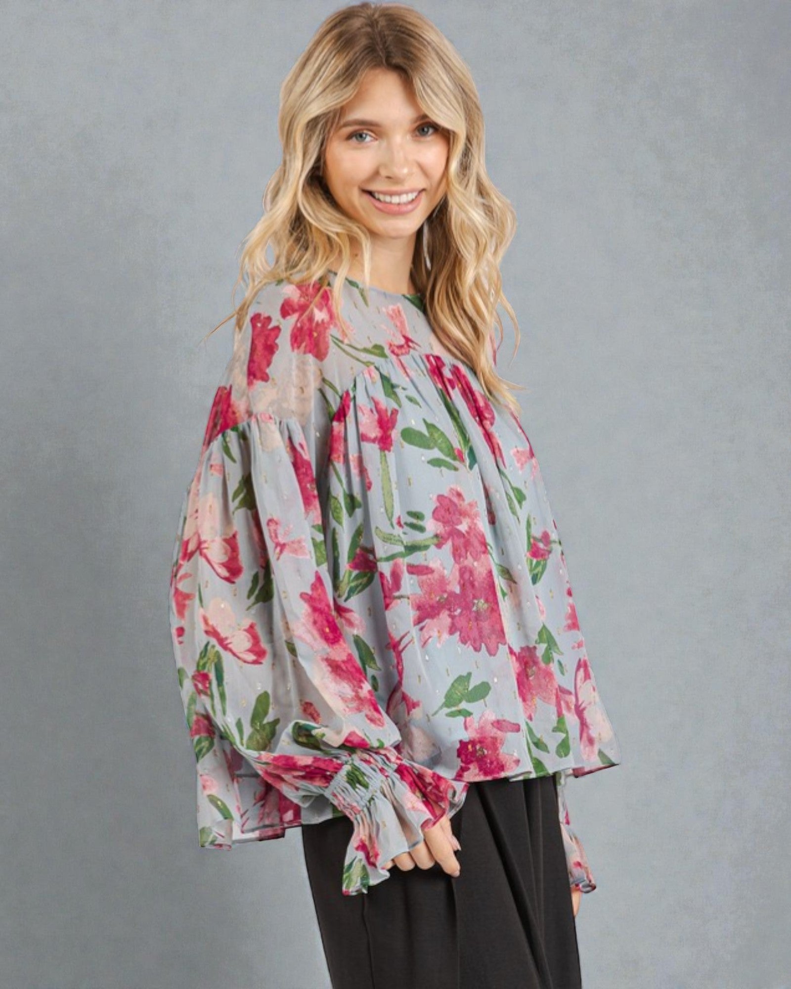 Woman wearing a floral blouse against a gray background
