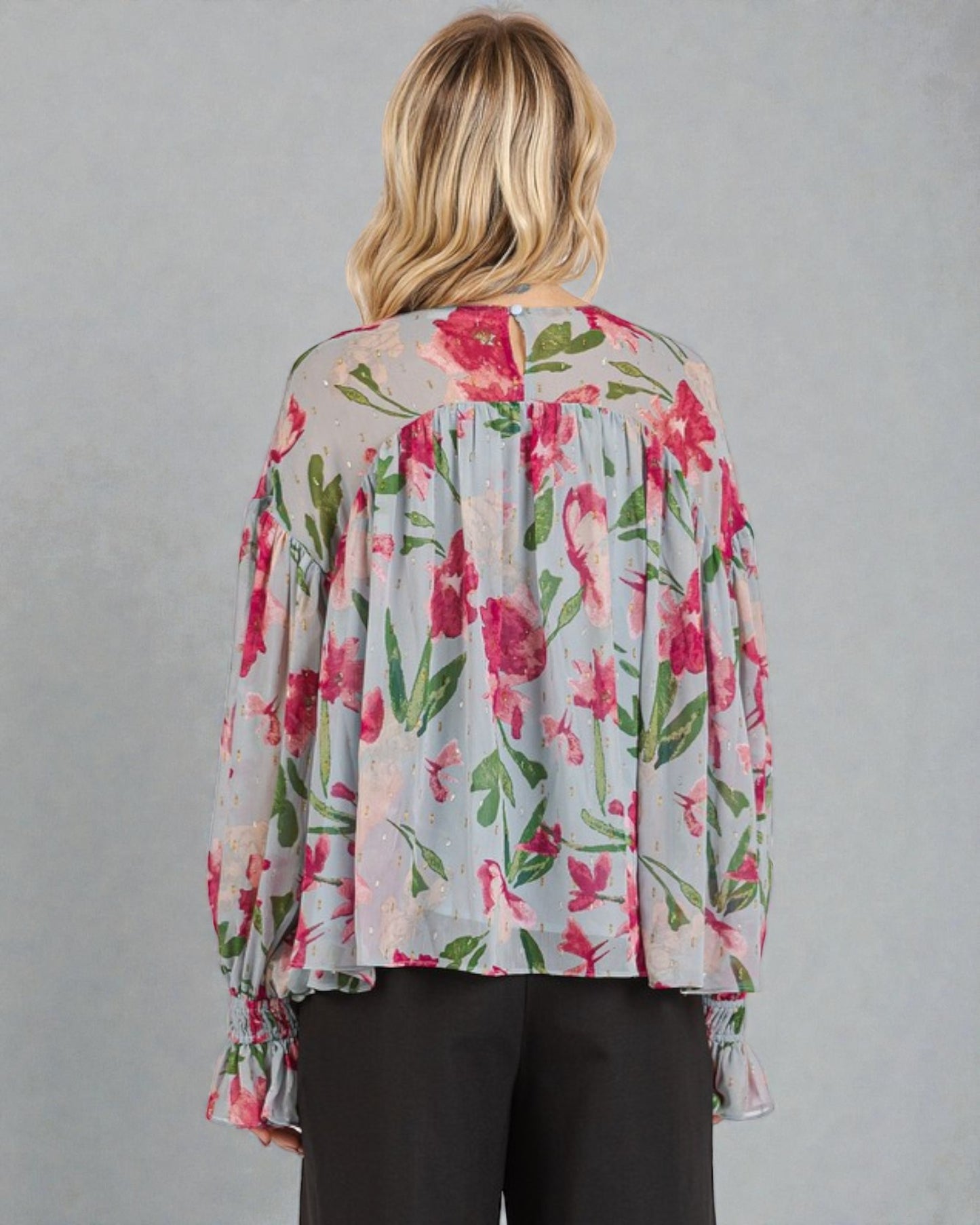 Woman wearing a floral blouse with a gray background