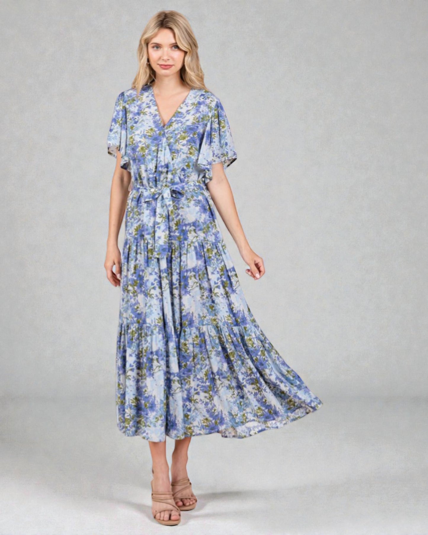 Woman wearing a blue floral dress on a gray background