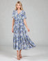 Woman wearing a blue floral dress on a gray background