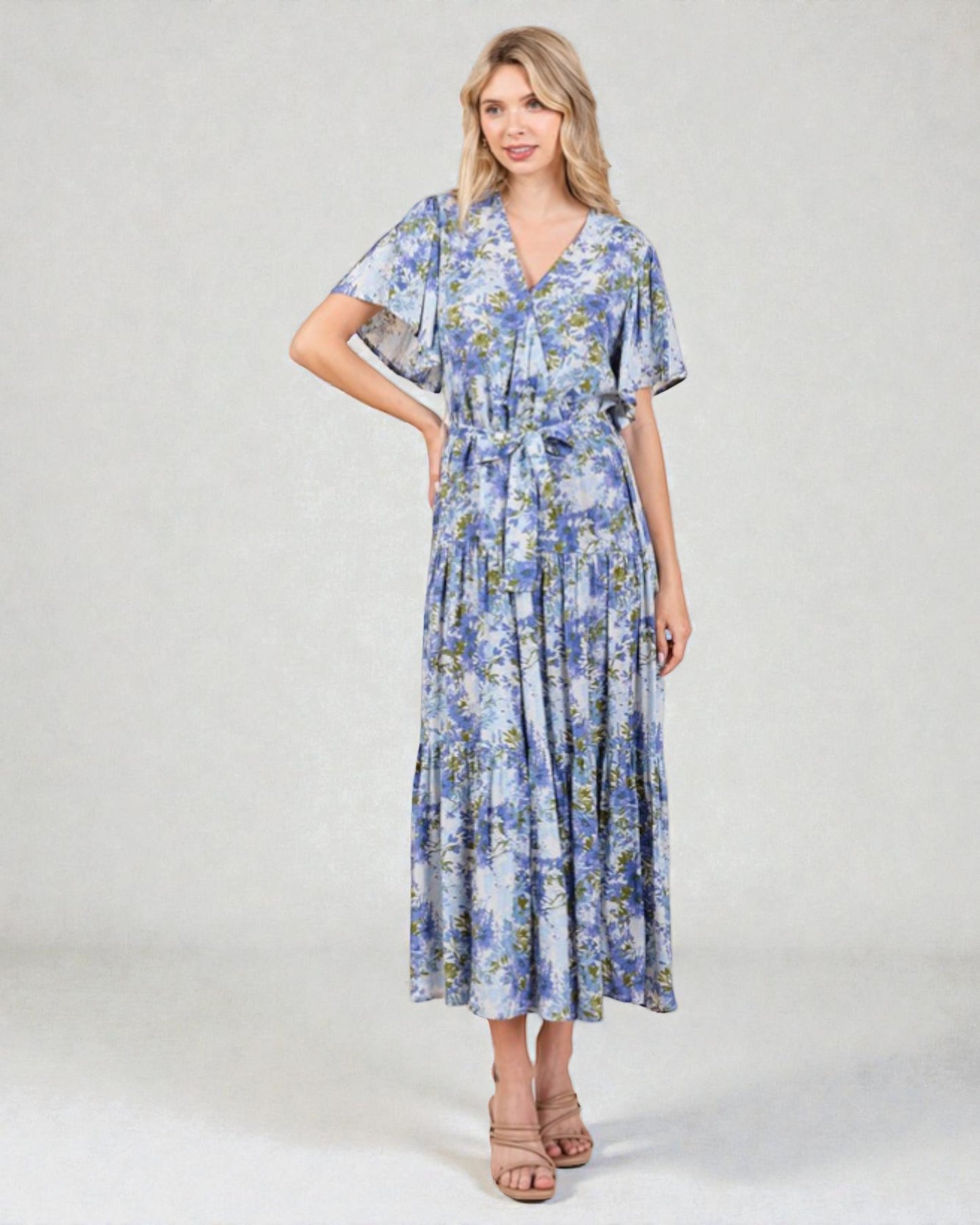 Woman wearing a blue floral dress on a gray background