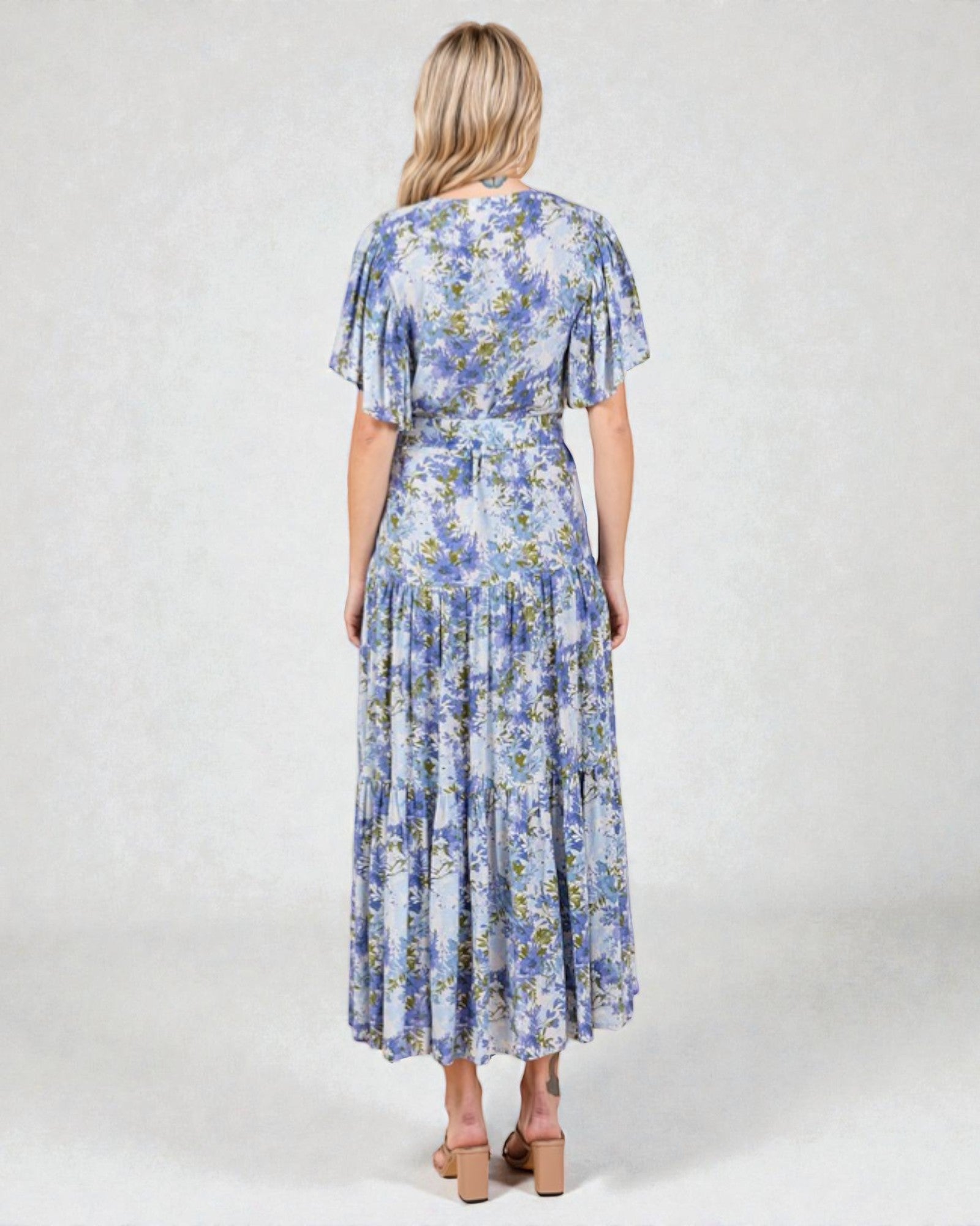 Woman wearing a blue floral dress on a white background