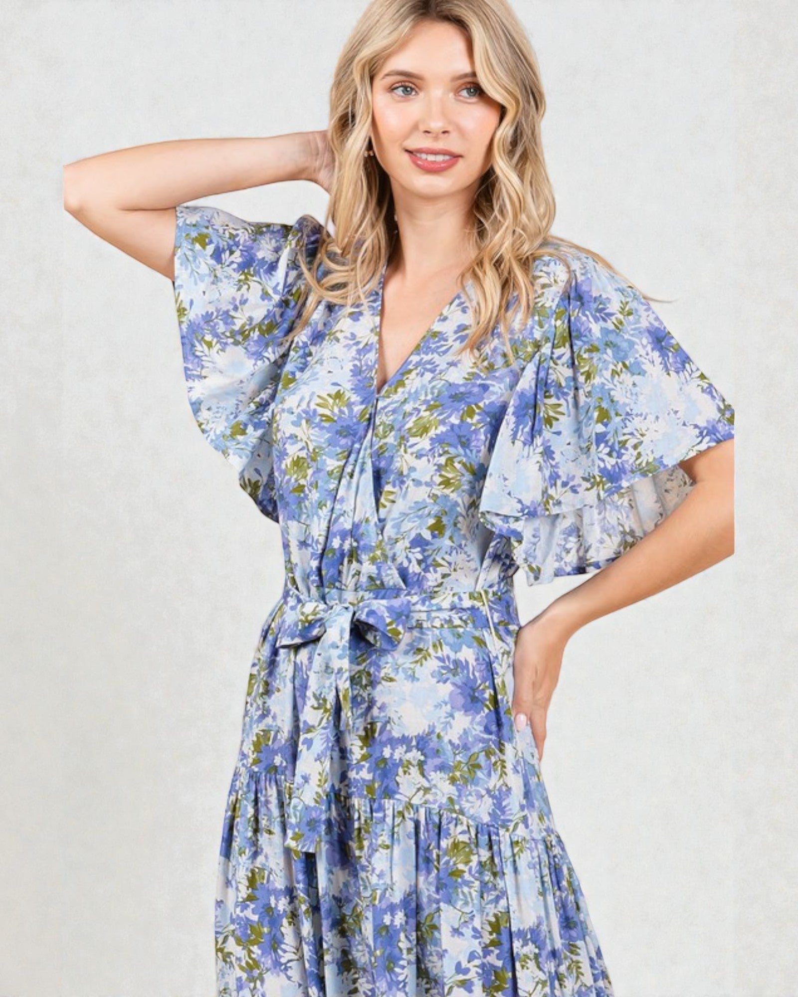 Woman wearing a blue floral dress against a white background
