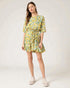 Woman wearing a yellow floral dress on a white background