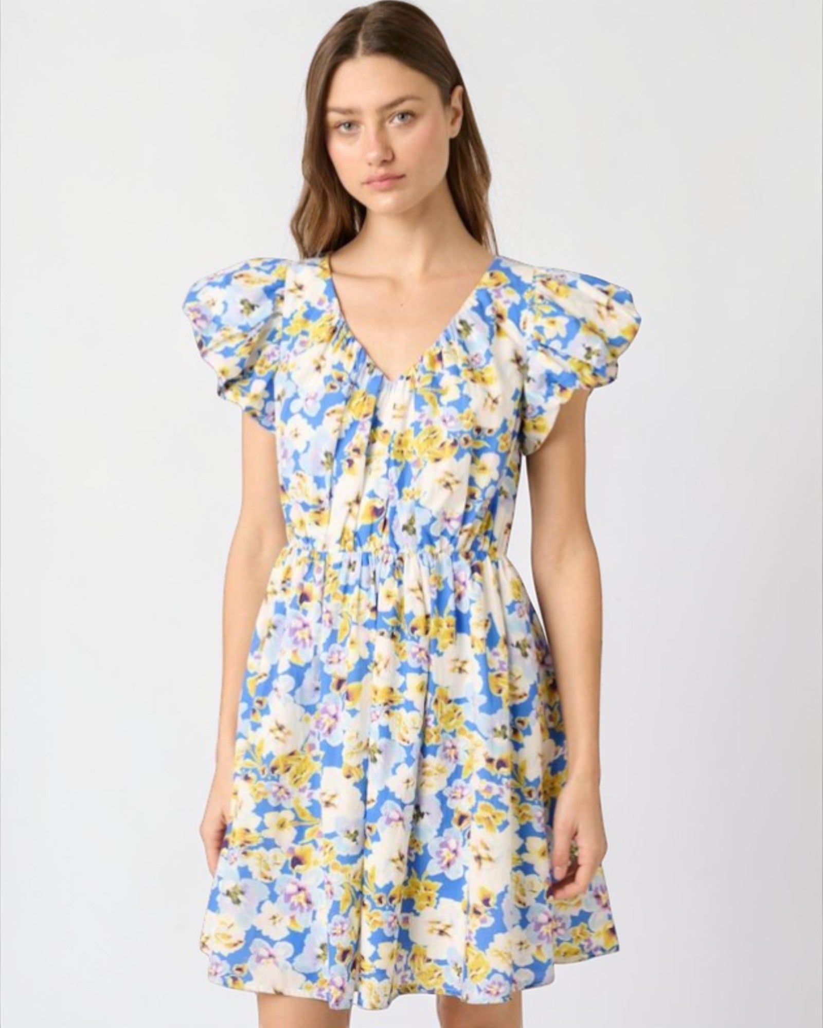 Woman wearing a floral dress with puffed sleeves on a white background