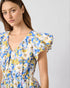 Woman wearing a blue floral dress against a plain background
