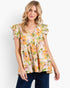 A woman wearing a short-sleeve peplum blouse with a vibrant orange, yellow, and green floral print on a cream background, paired with dark blue jeans, against a plain white studio background.