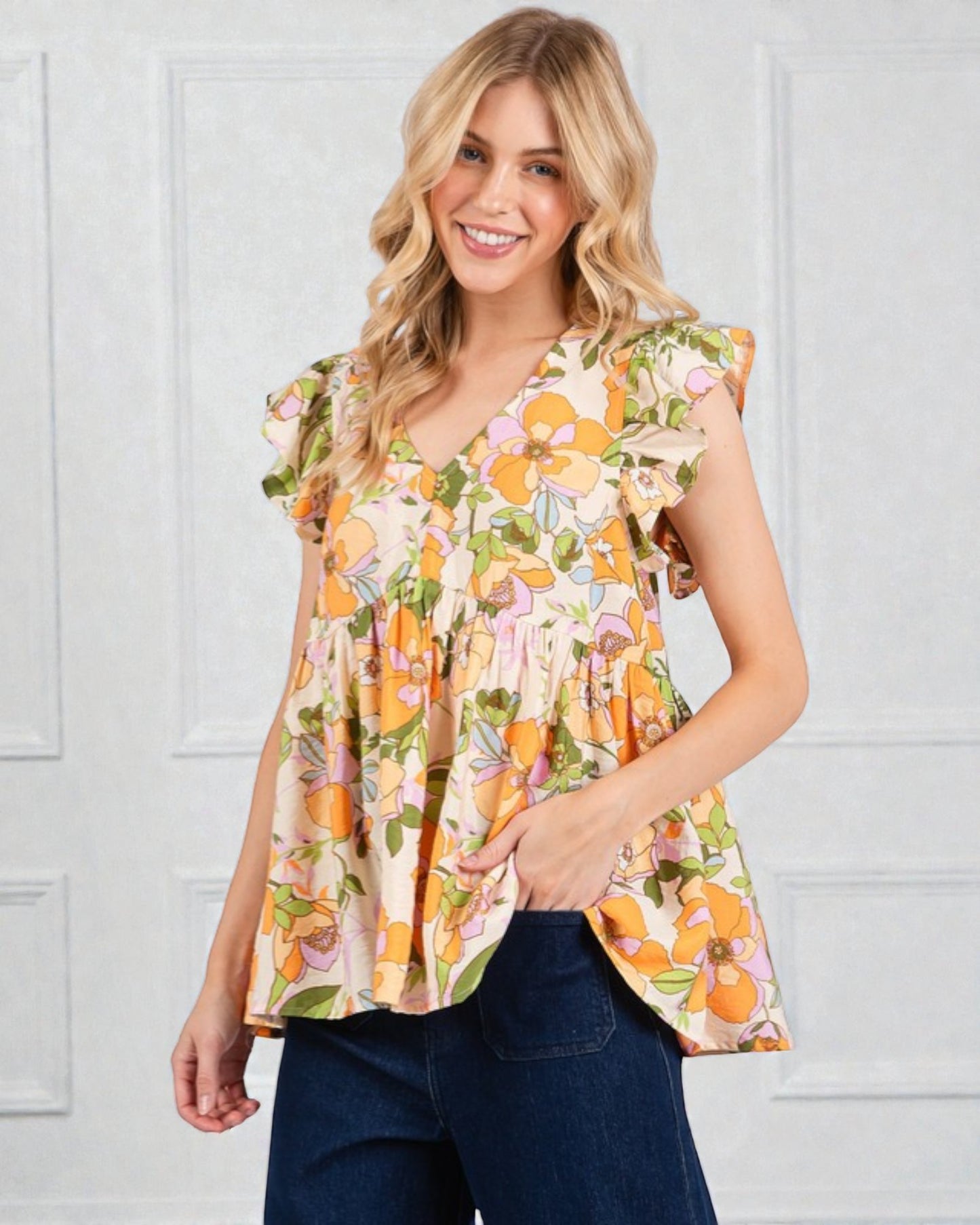 Woman wearing a floral blouse with pumpkins and leaves in front of a white background
