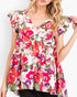 A woman wearing a short-sleeve V-neck top with a colorful floral print, featuring red, pink, orange, and green flowers on a light background.