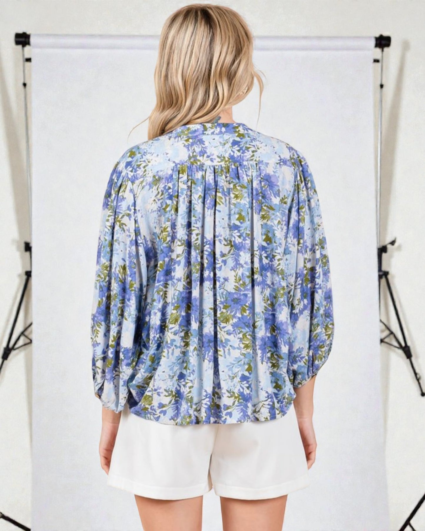 Woman wearing a blue floral blouse against a white background