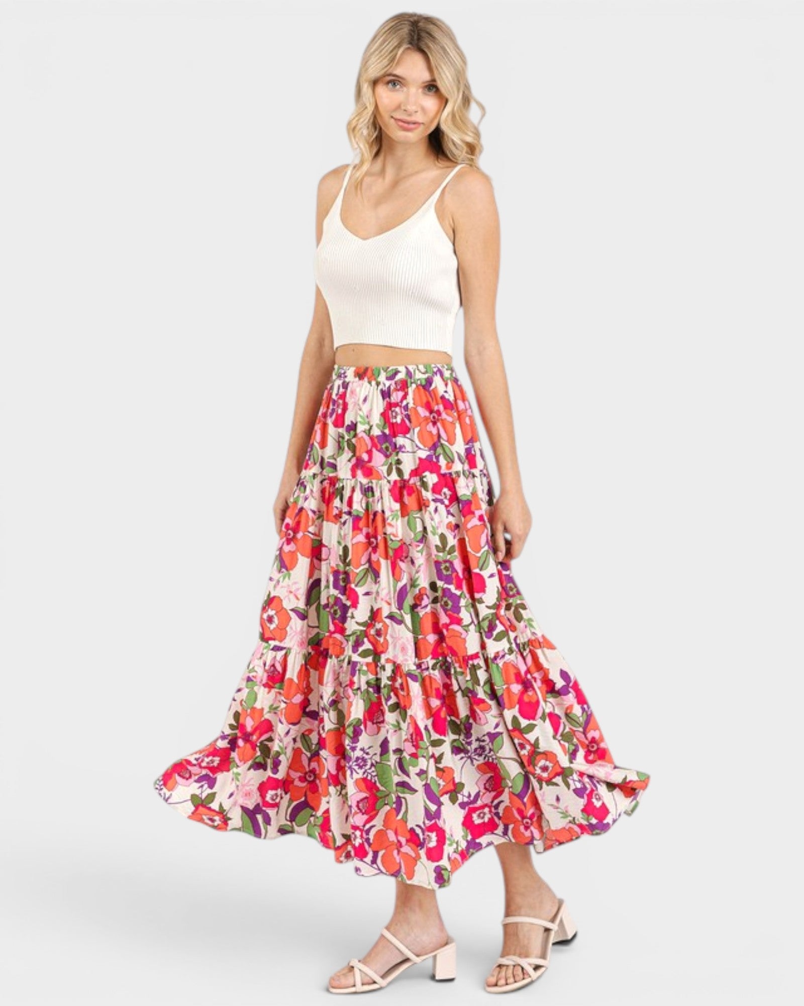 Woman wearing a floral skirt and white top on a white background