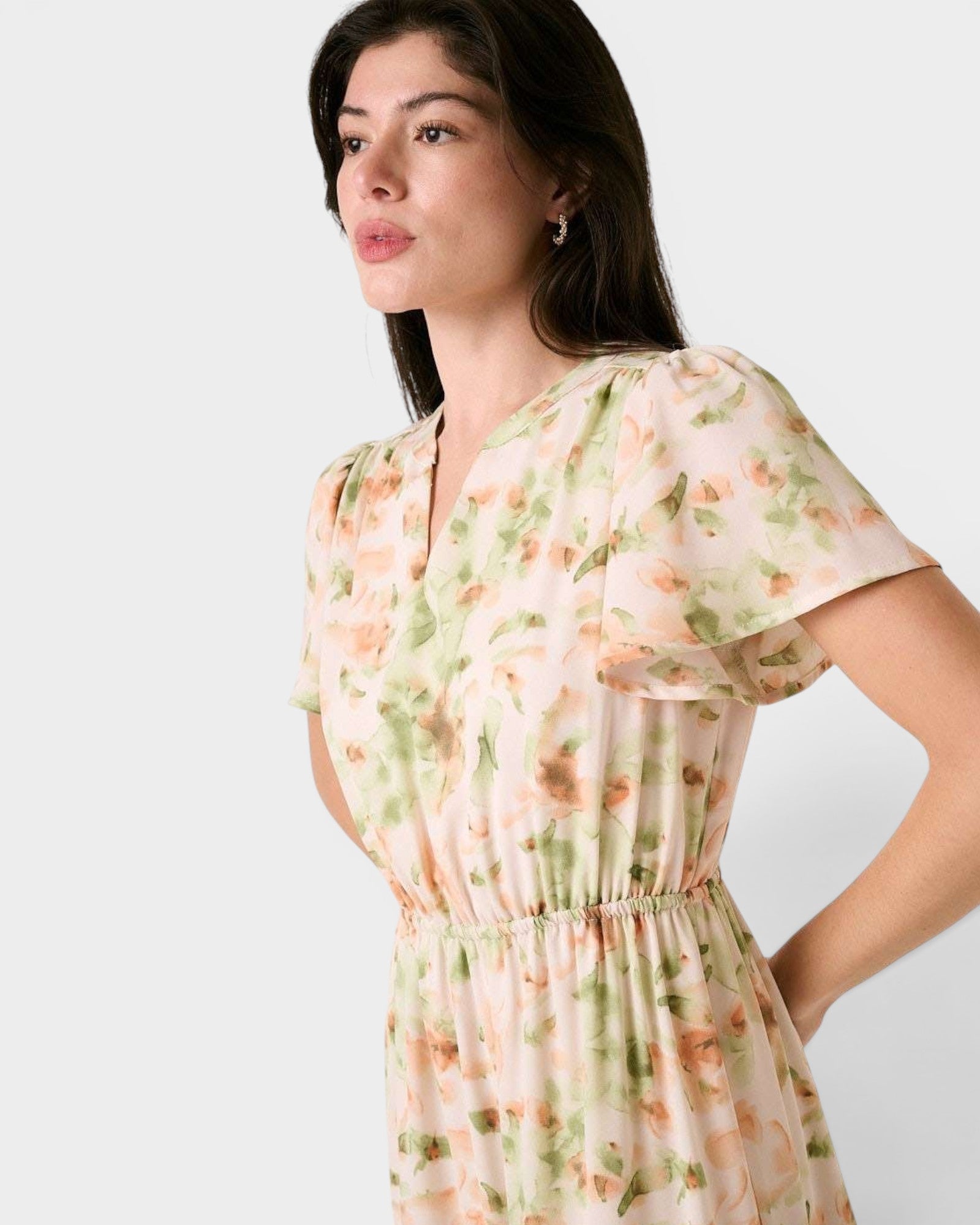 Woman wearing a floral dress against a plain background
