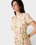 Woman wearing a floral dress against a plain background