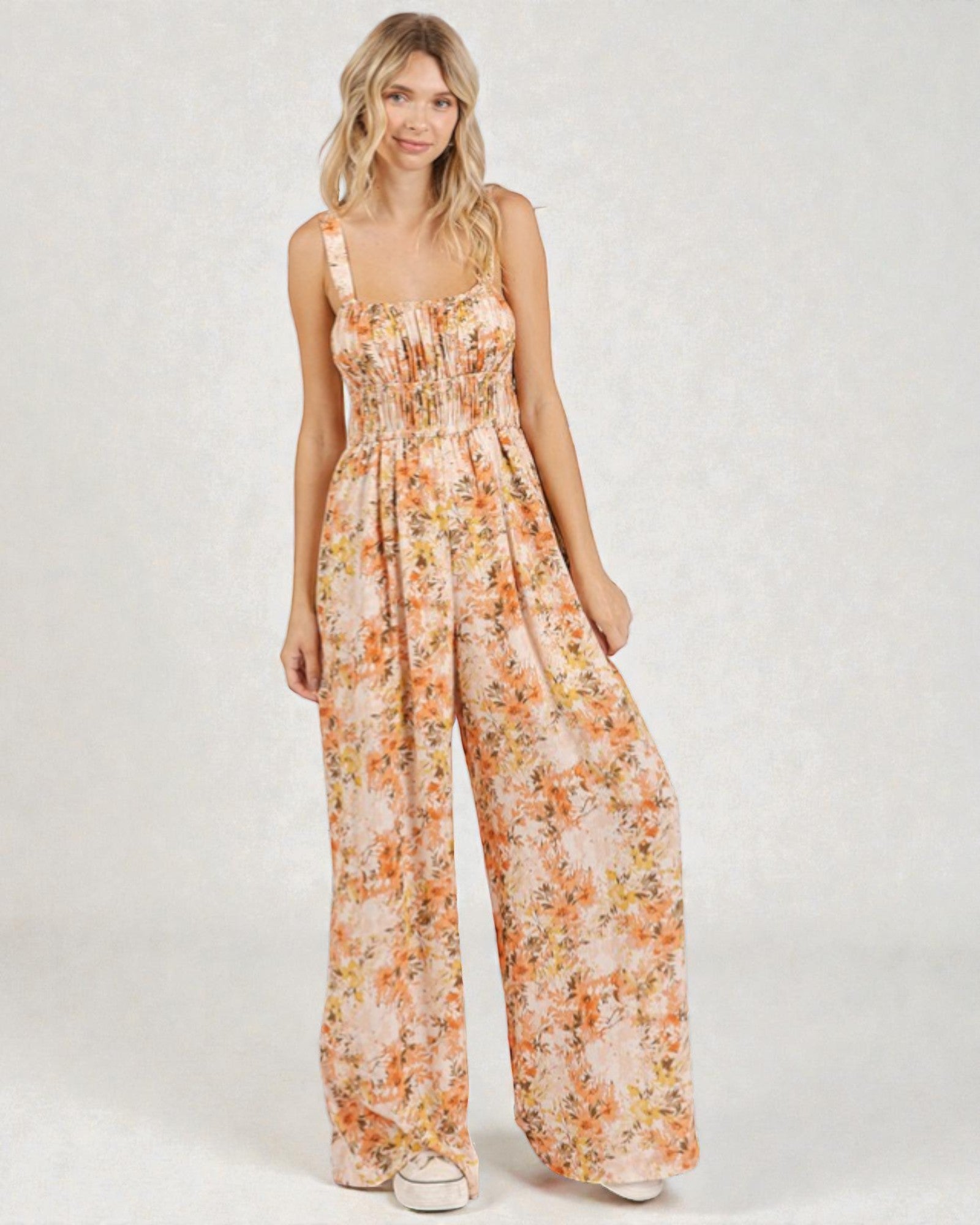 Woman wearing a floral jumpsuit on a white background