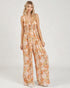 Woman wearing a floral jumpsuit on a white background