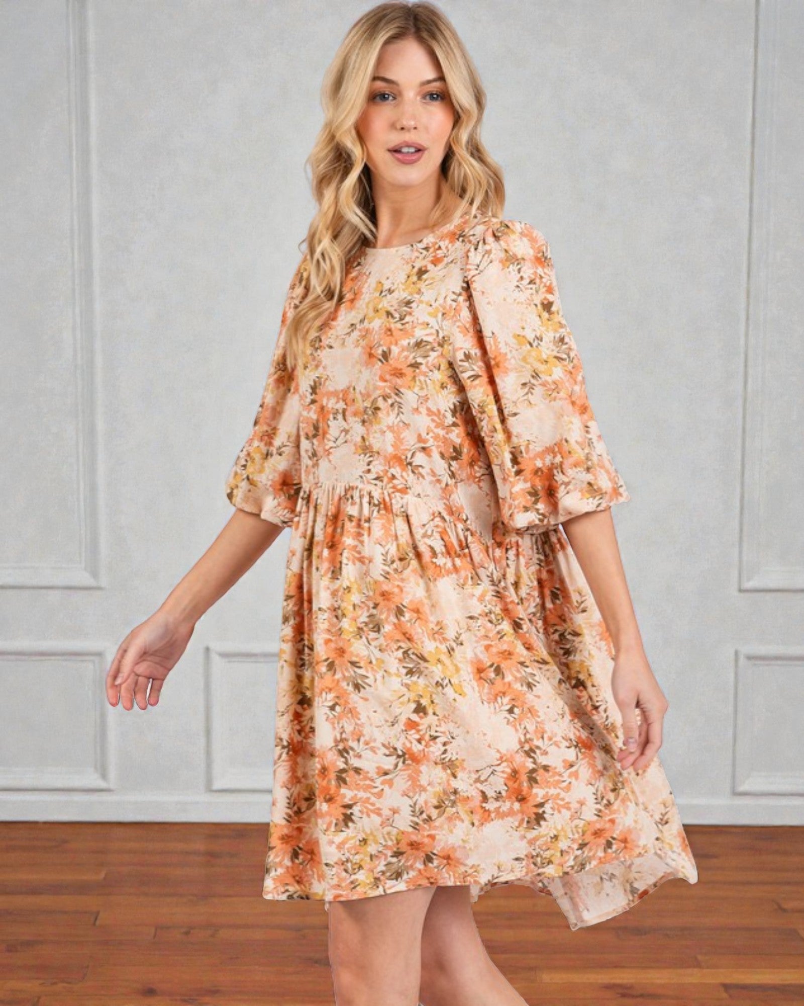 Woman wearing a floral dress against a plain background