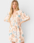Woman wearing a floral dress on a plain background