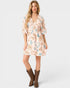 Woman wearing a floral dress with brown boots on a white background