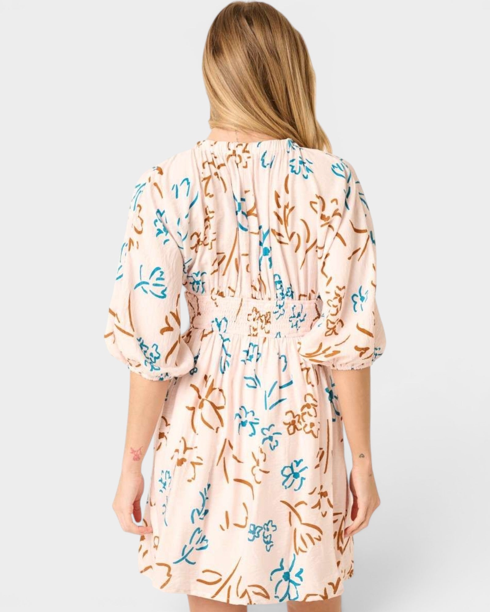 Woman wearing a floral dress with a plain background