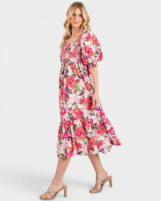 Woman wearing a colorful floral dress on a white background