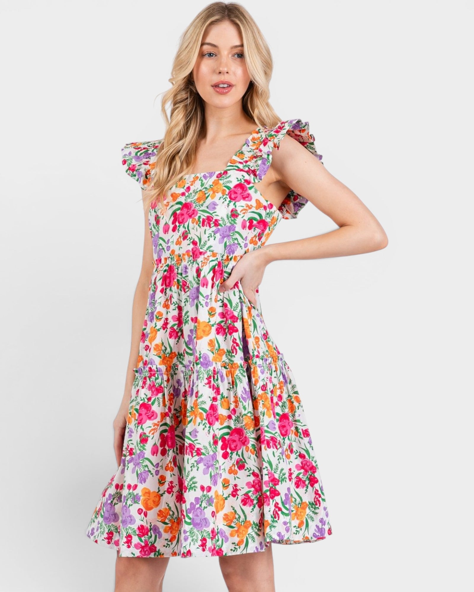 Woman wearing a colorful floral dress on a white background
