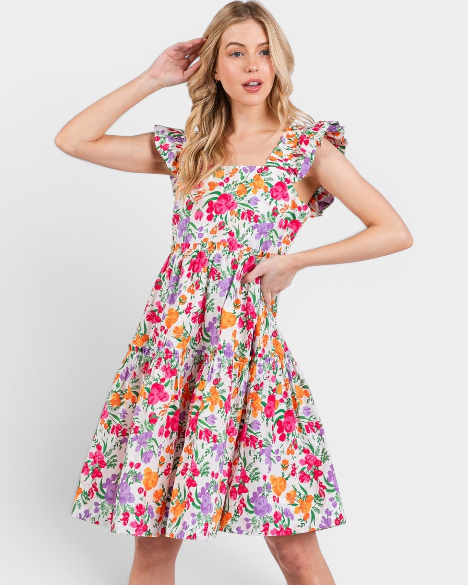 Woman wearing a colorful floral dress on a white background