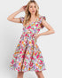 Woman wearing a colorful floral dress on a white background