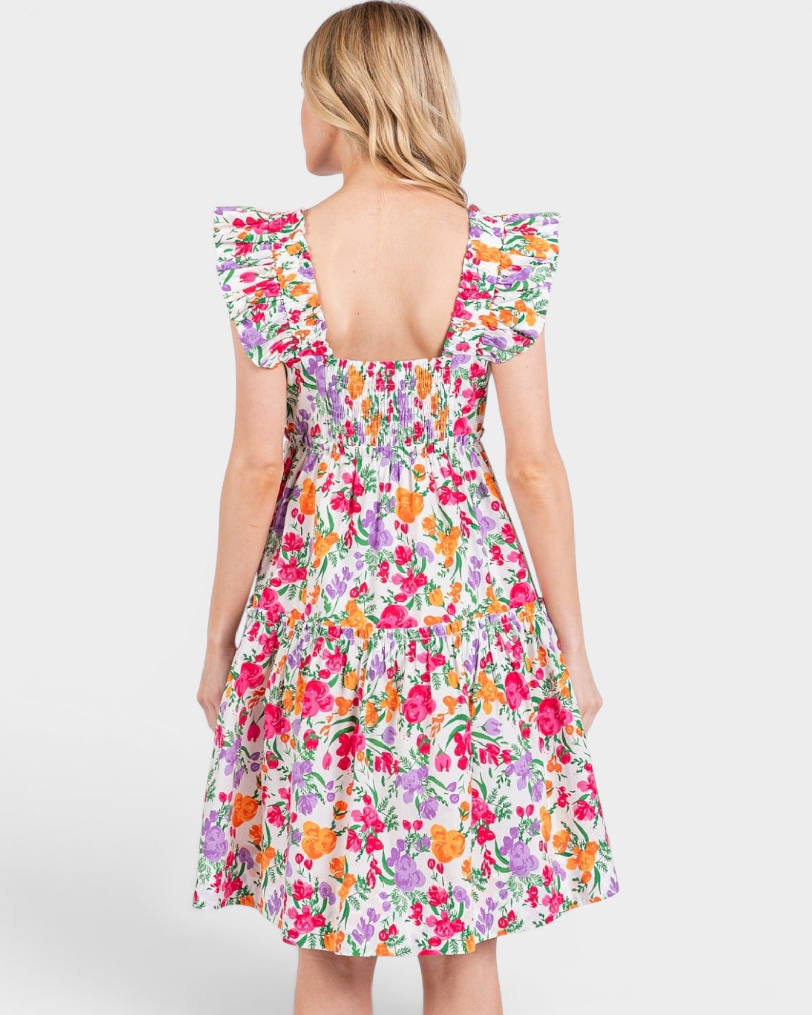 Woman wearing a colorful floral dress on a white background