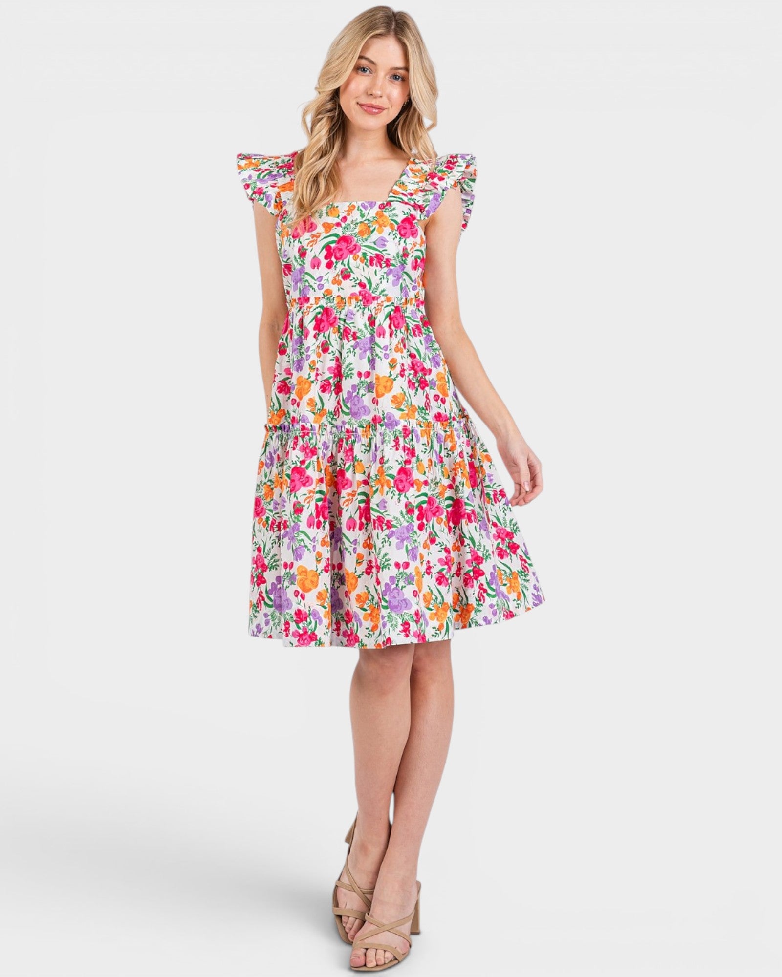 Woman wearing a colorful floral dress on a white background