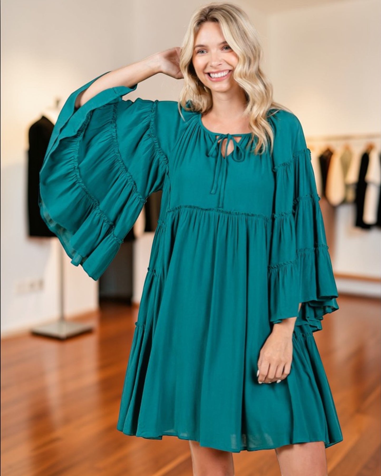 Woman wearing a teal dress in a clothing store