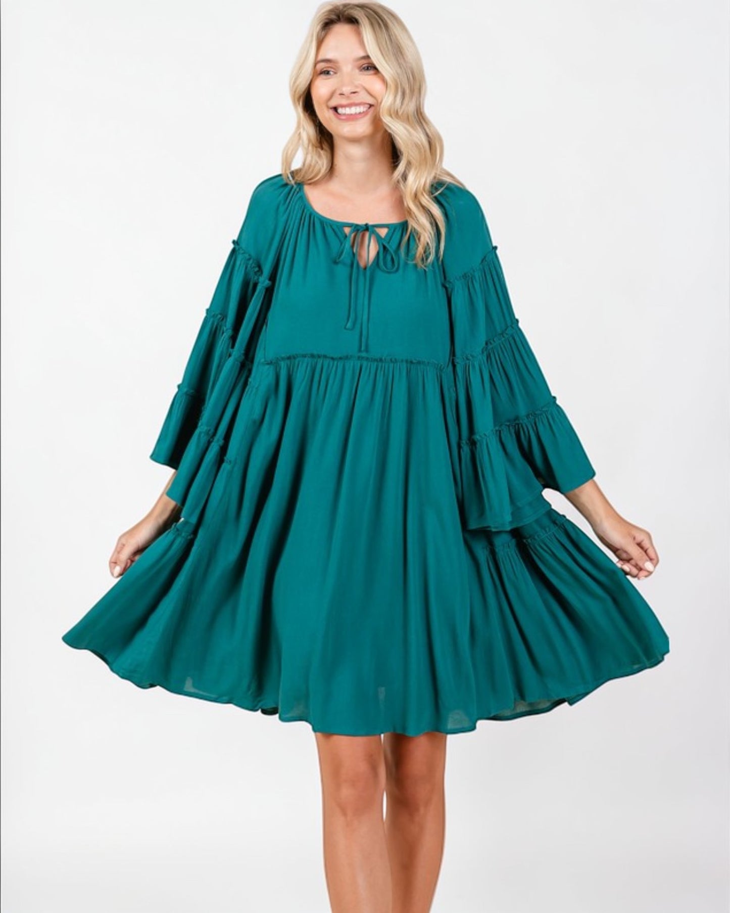 Woman wearing a teal dress on a white background