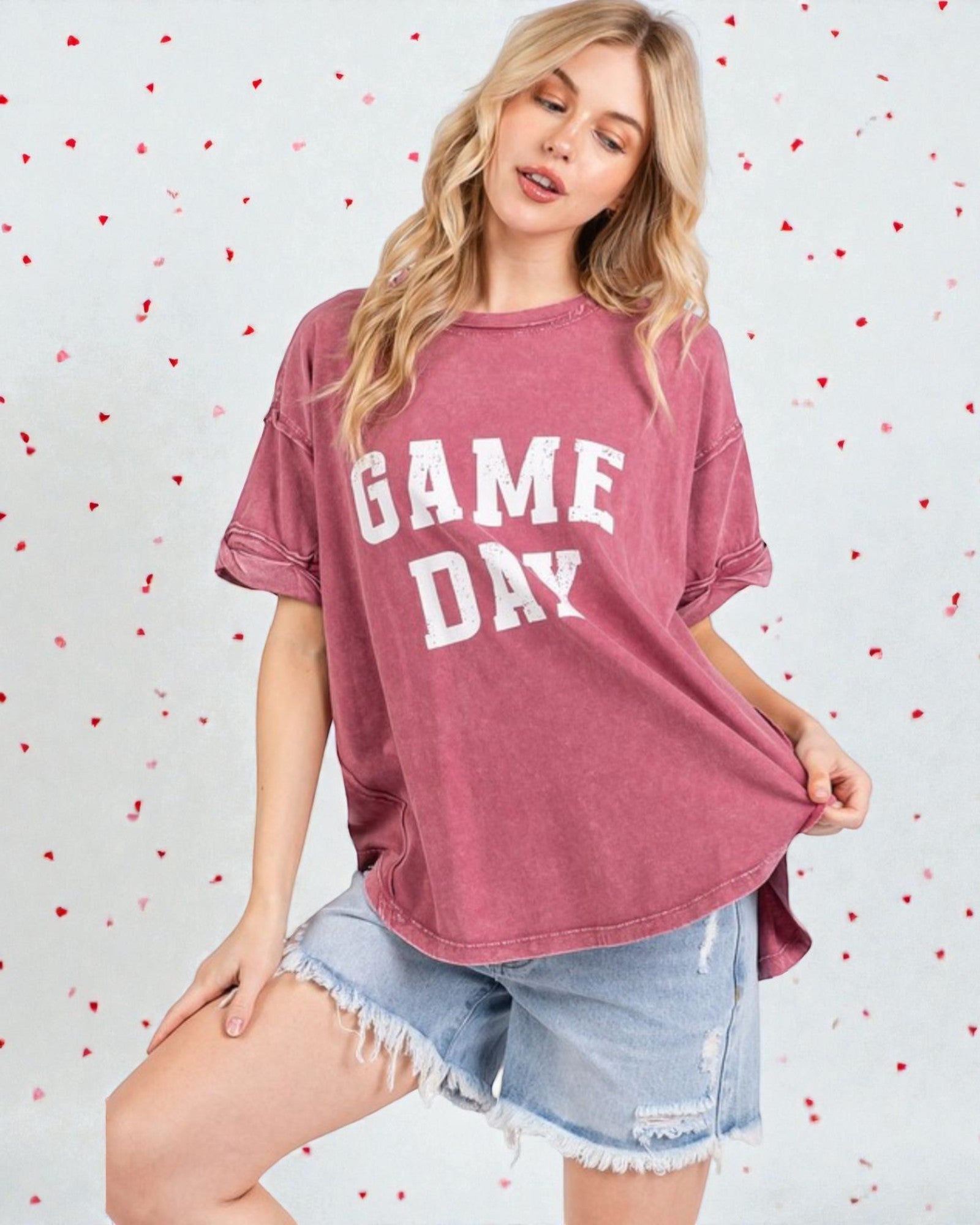 Woman wearing a 'GAME DAY' t-shirt with a heart-patterned background