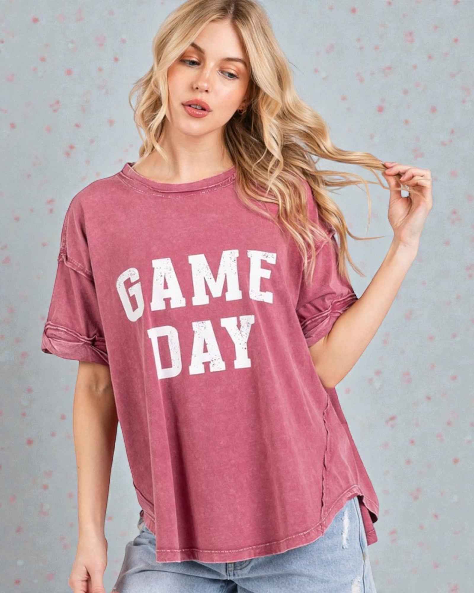 Woman wearing a maroon 'GAME DAY' t-shirt against a light gray background