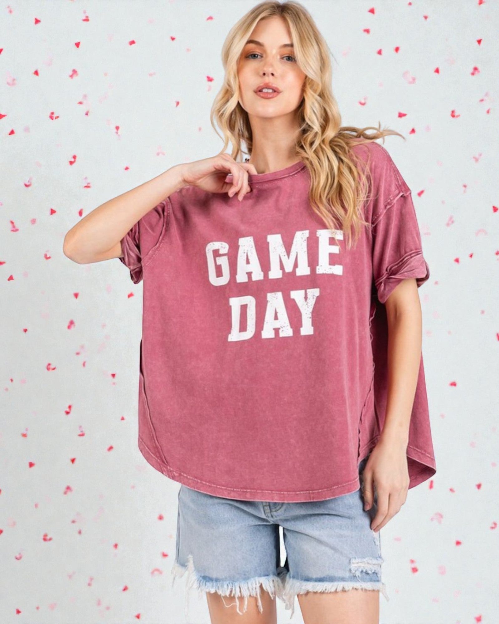 Woman wearing a 'GAME DAY' t-shirt with a heart-patterned background