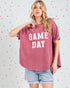 Woman wearing a 'GAME DAY' t-shirt with a heart-patterned background