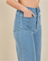 Light blue jeans worn by a person on a beige background