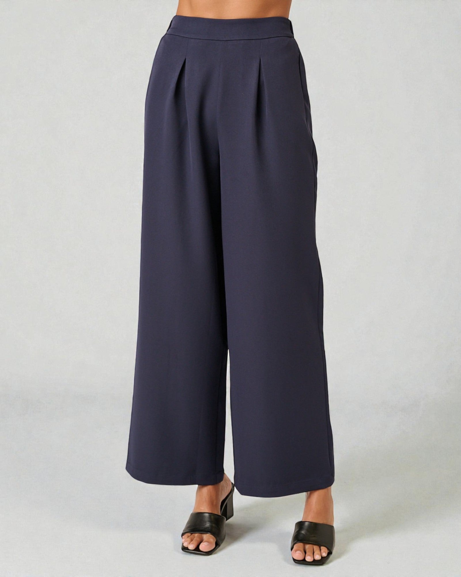 Navy wide-leg pants worn by a person on a light gray background