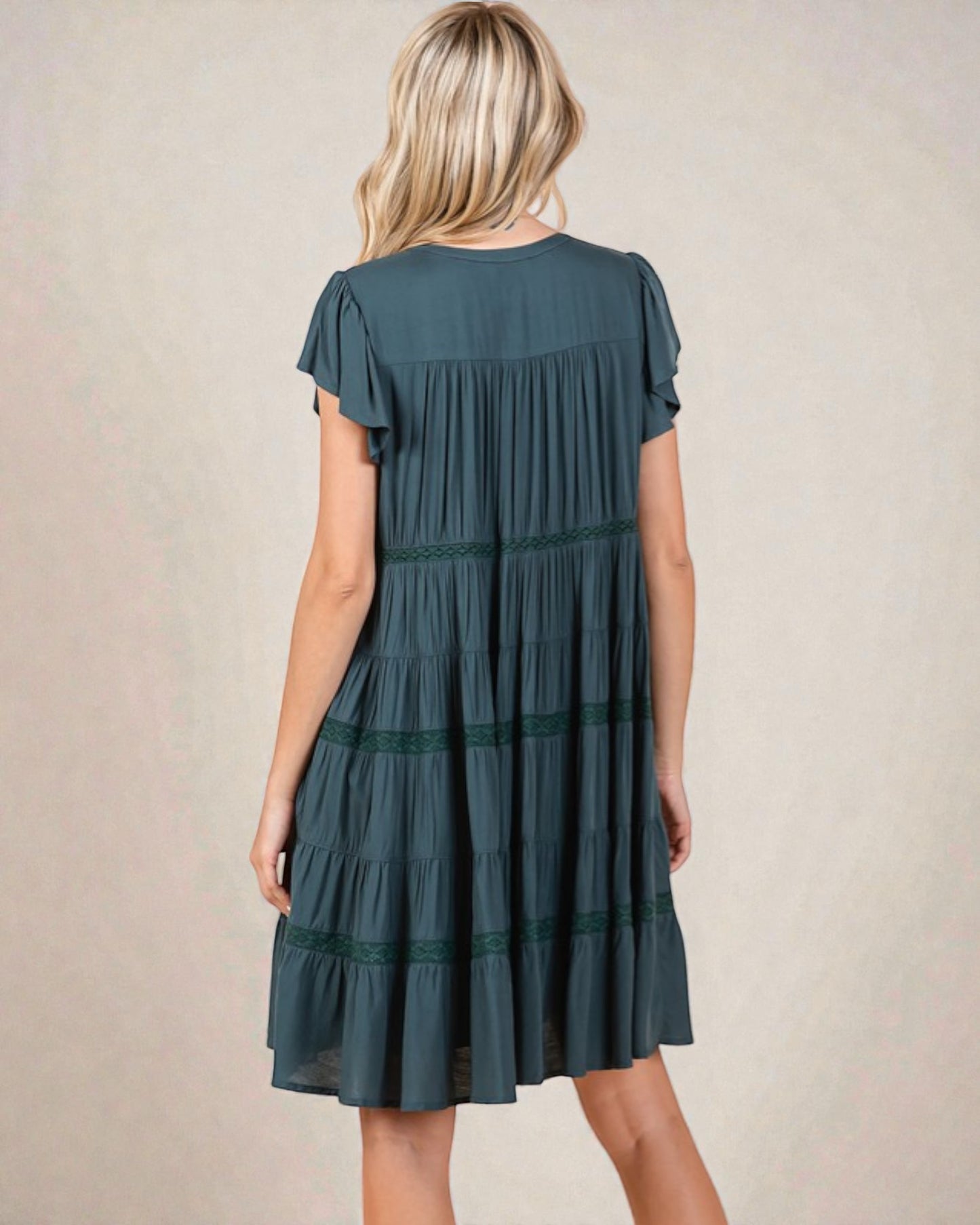 Woman wearing a green dress with a plain background