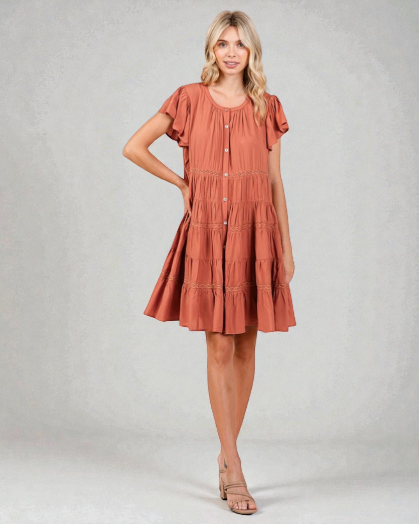 Woman wearing a rust-colored dress on a plain background