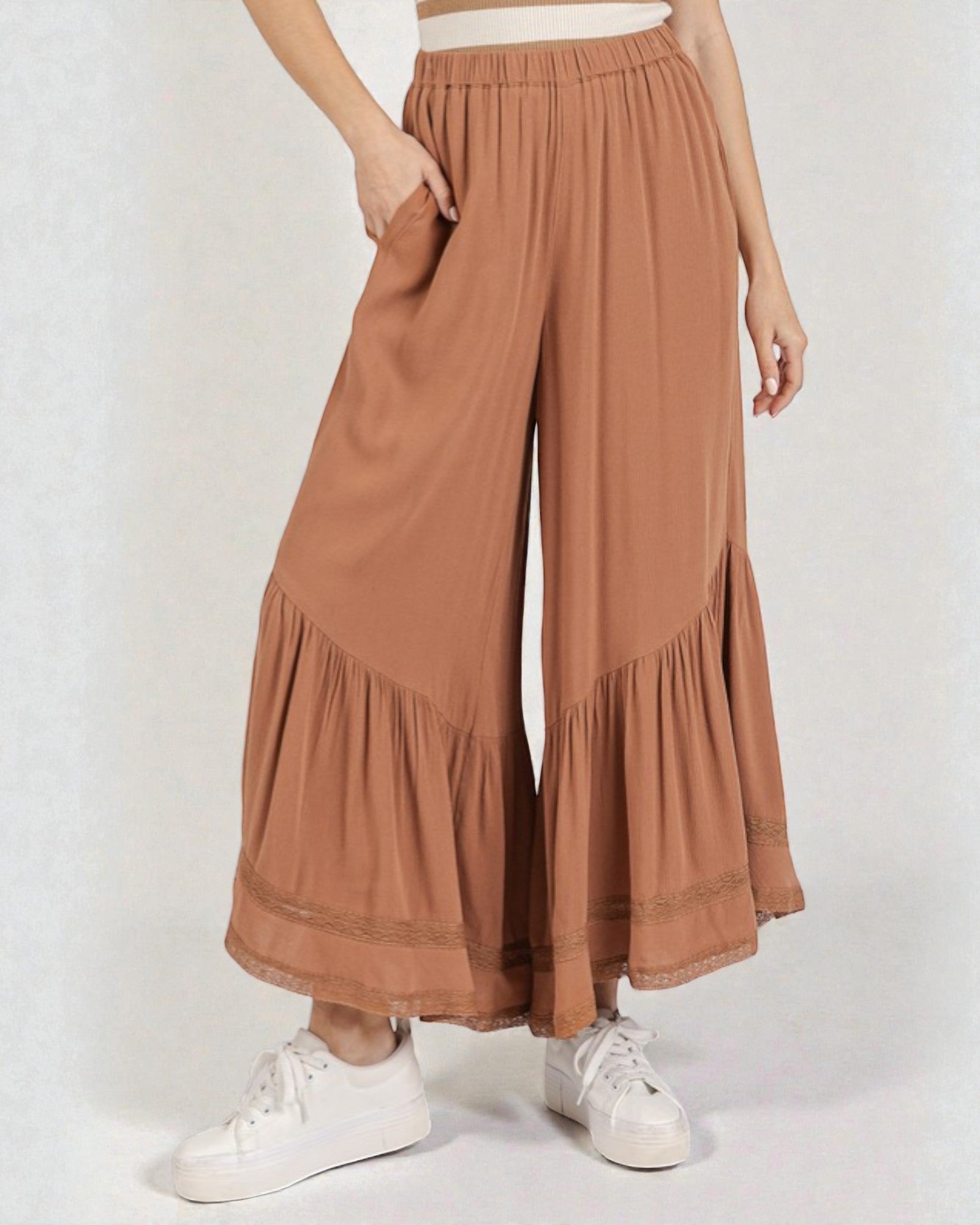 Brown wide-leg pants worn by a person on a white background