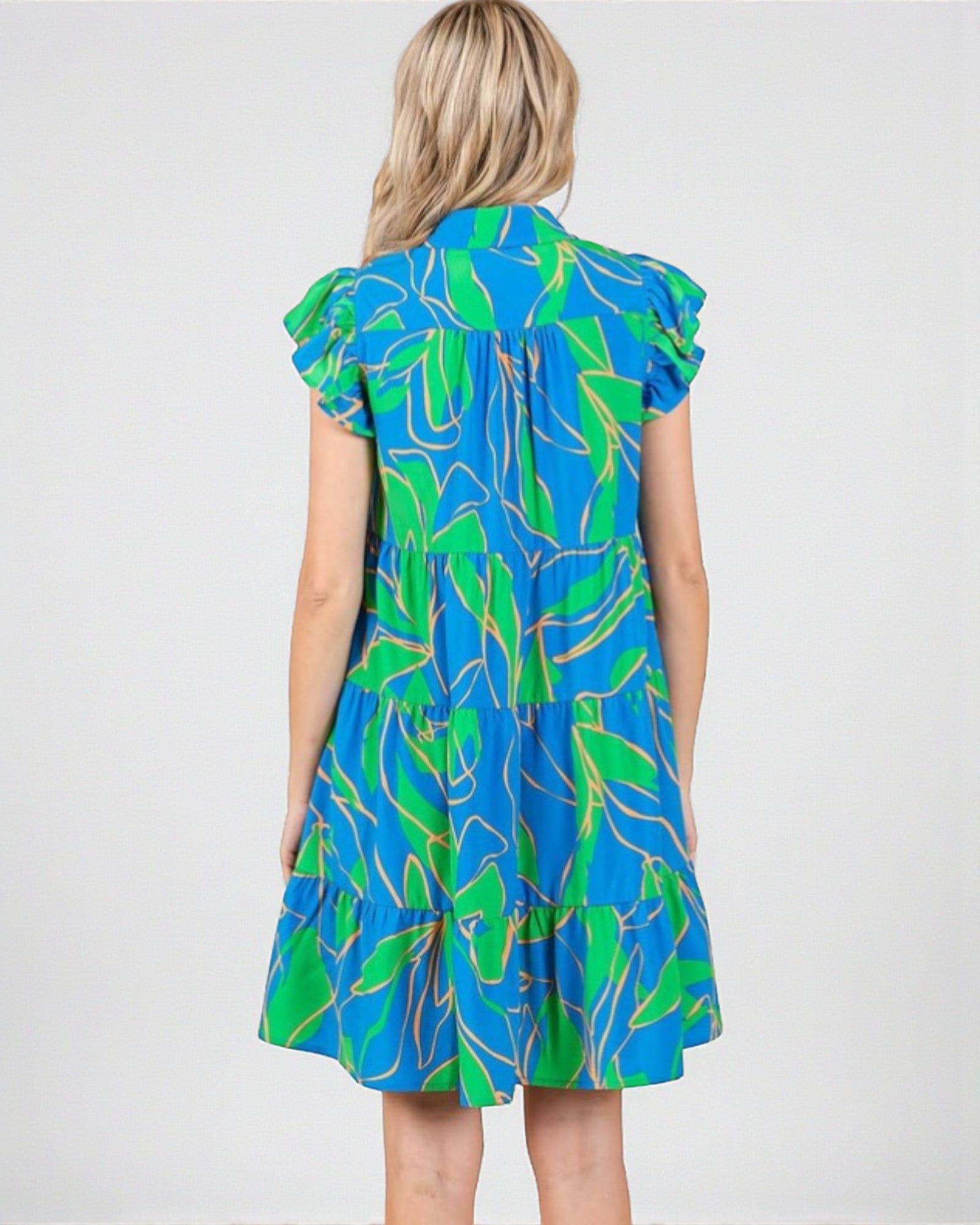 Woman wearing a blue and green patterned dress on a white background