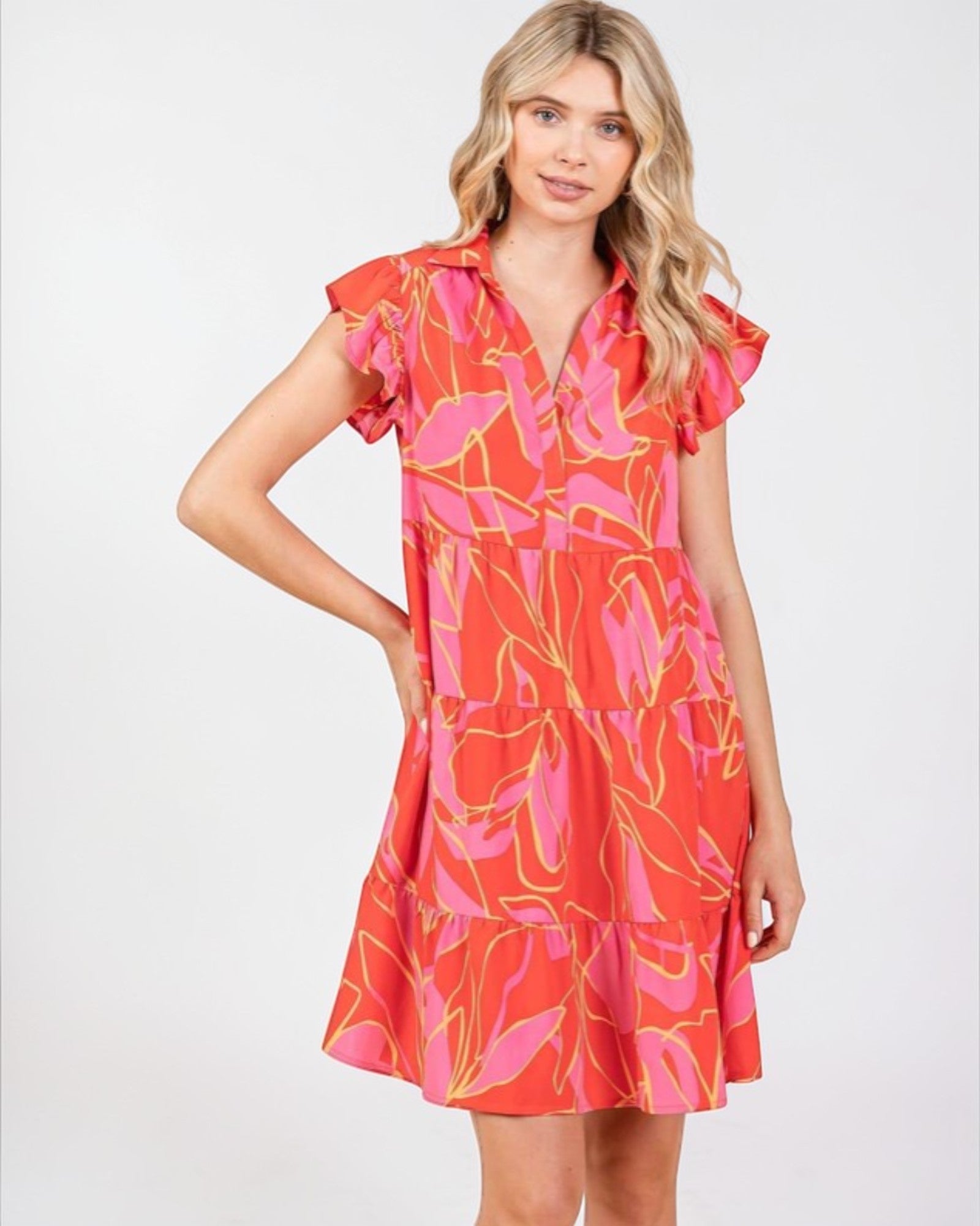 Woman wearing a red and pink floral dress on a white background