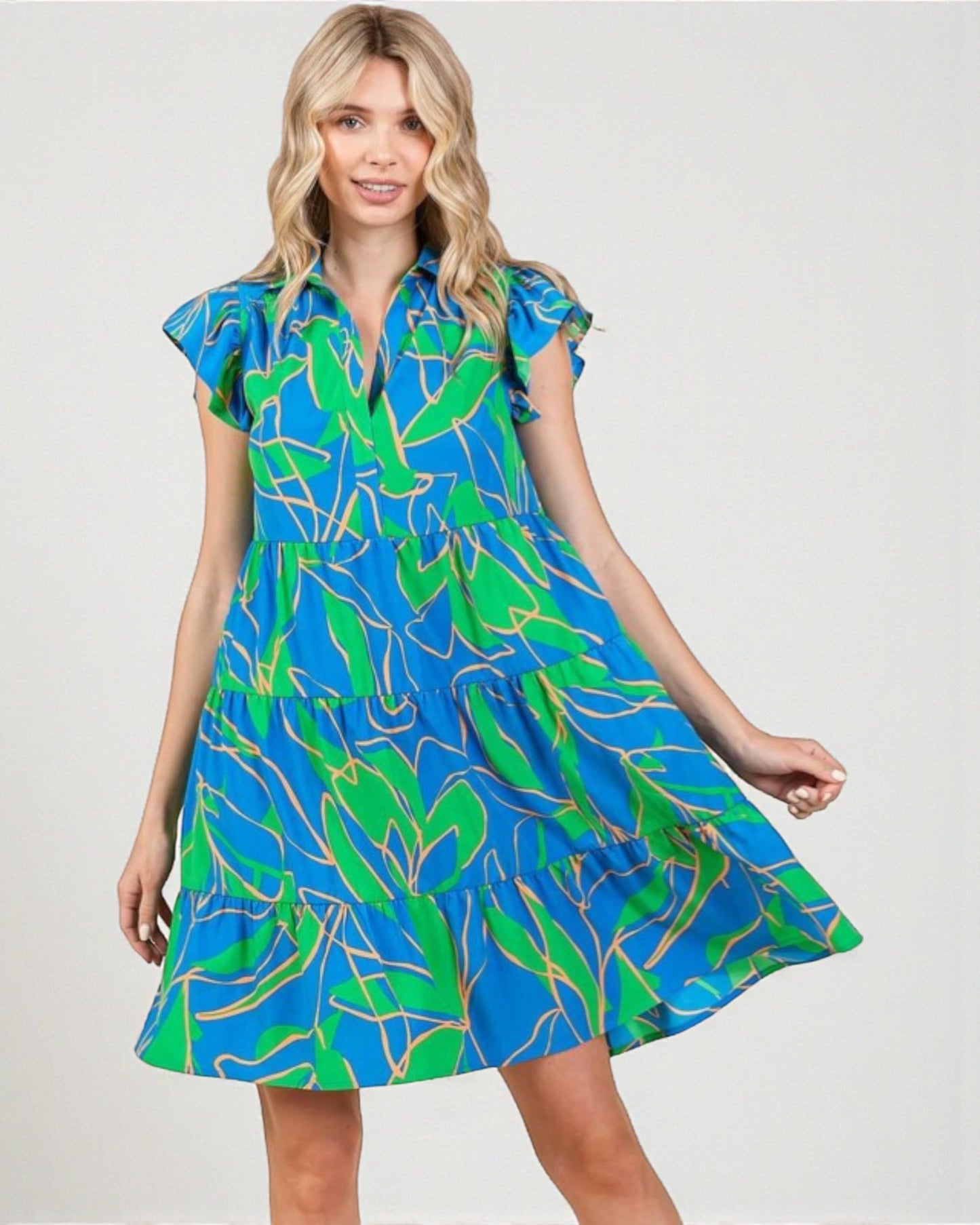 Woman wearing a blue and green patterned dress on a white background