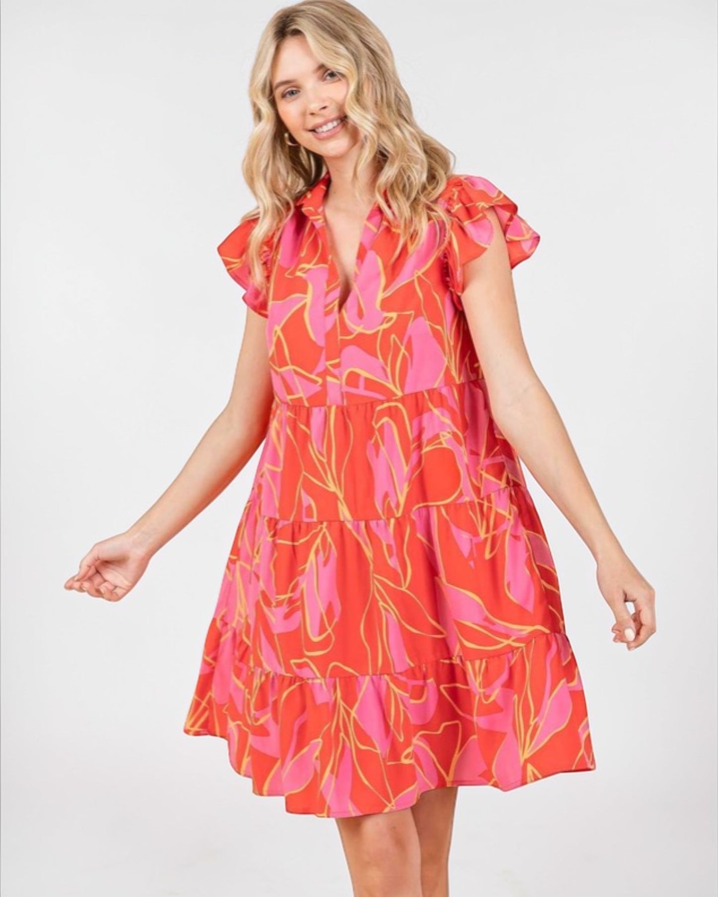 Woman wearing a red and pink floral dress on a white background