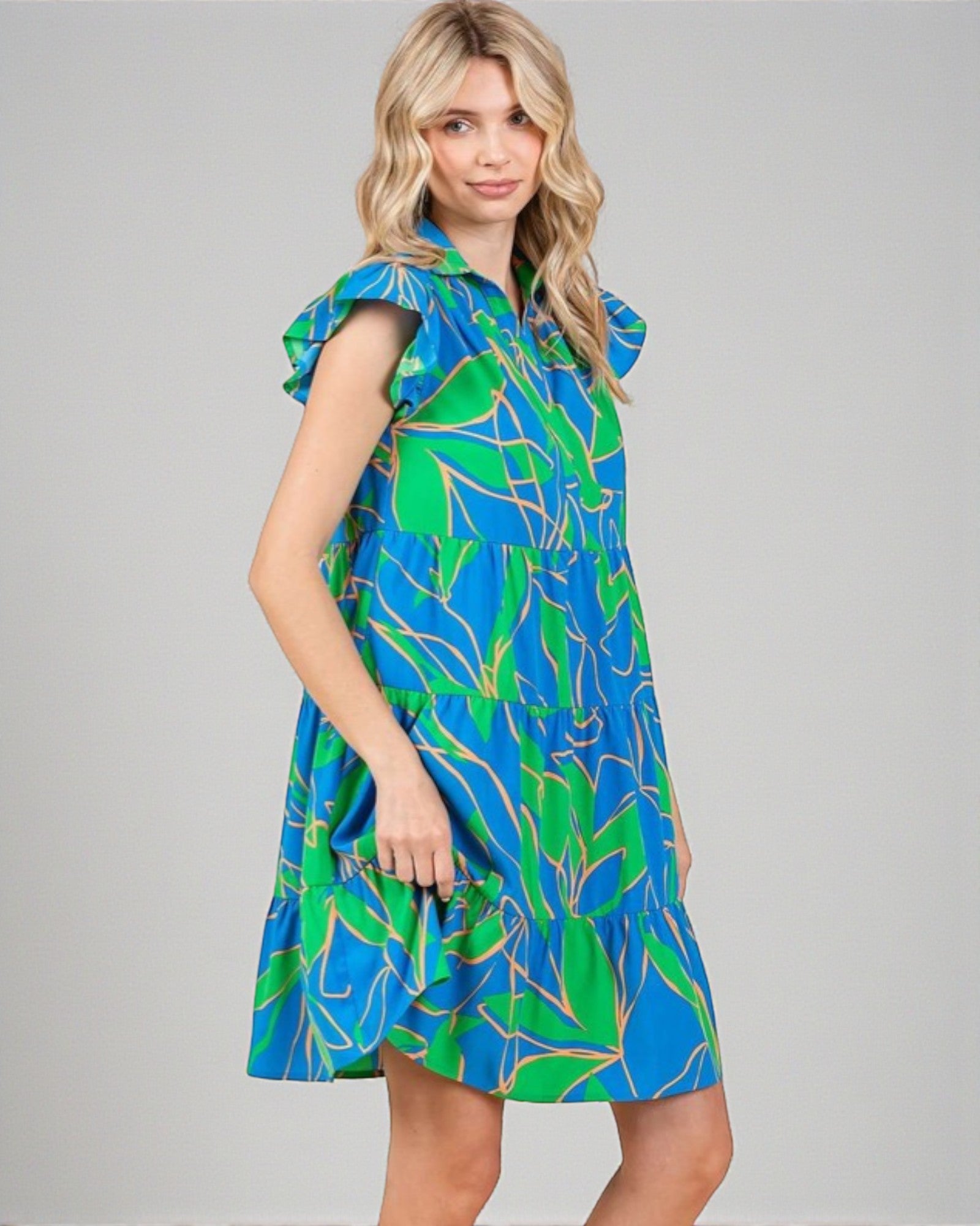 Woman wearing a blue and green patterned dress on a gray background