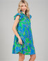 Woman wearing a blue and green patterned dress on a gray background
