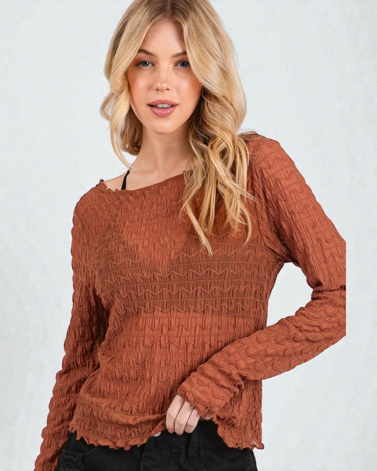 Woman wearing a brown textured sweater against a white background