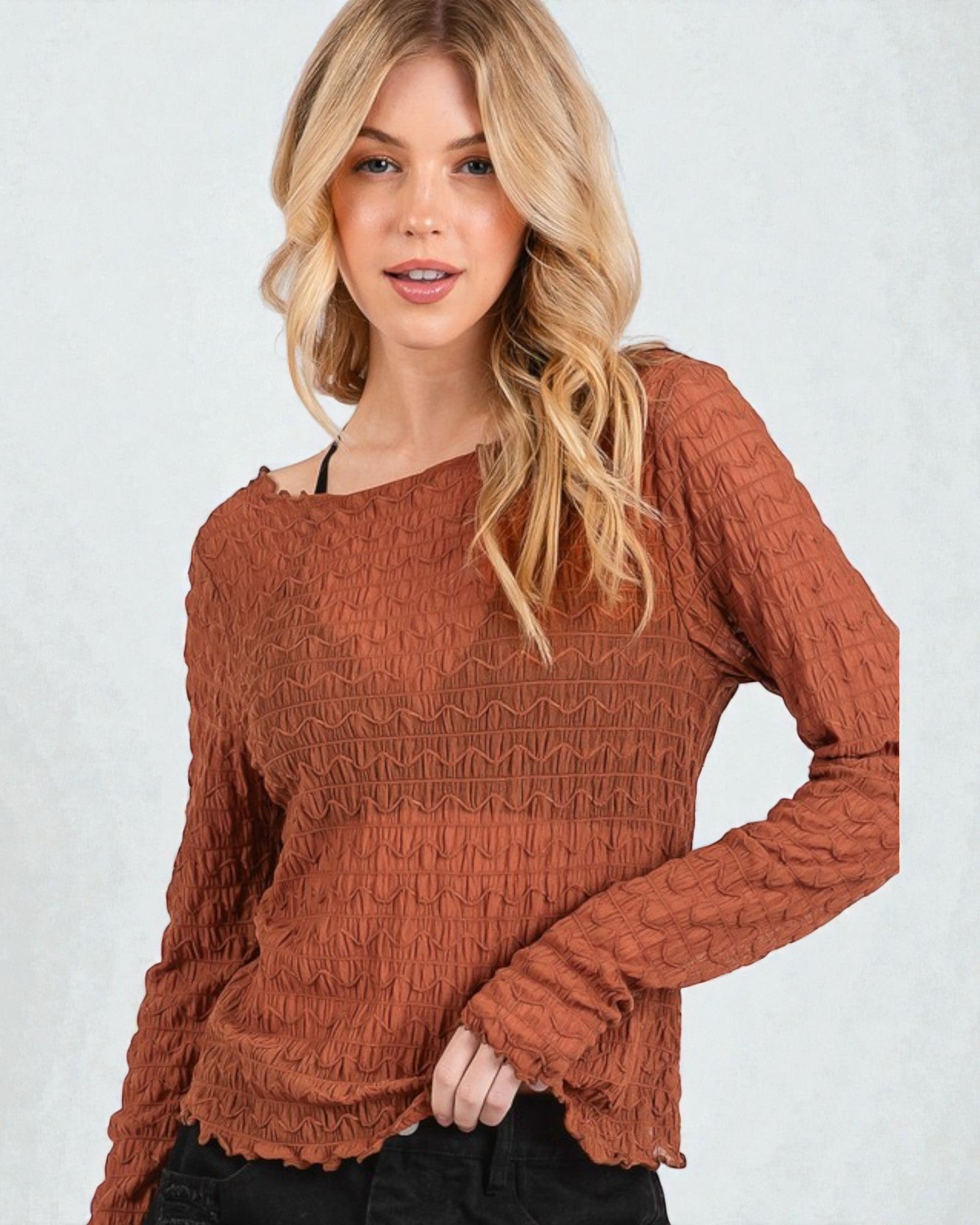Woman wearing a brown textured sweater against a white background